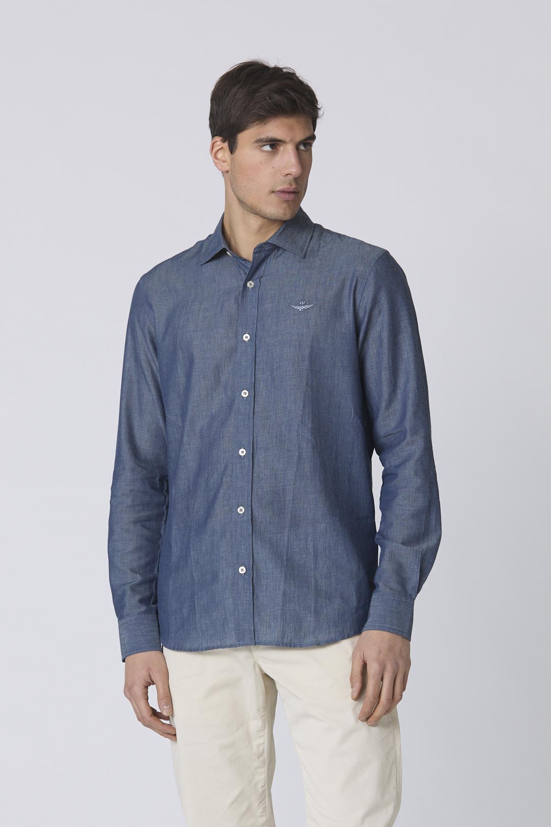 Dettaglio aquila turrita ricamata su camicia chambray Aeronautica Militare jeans blu